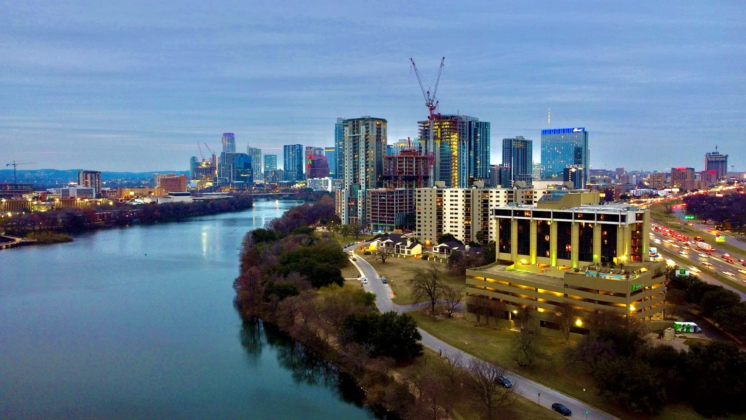 Aerial city skyline beside a river at dusk